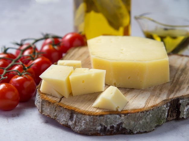 Concepto de comida sana casera: tomates cherry, rodajas de queso y aceite de oliva sobre fondo de hormigón claro