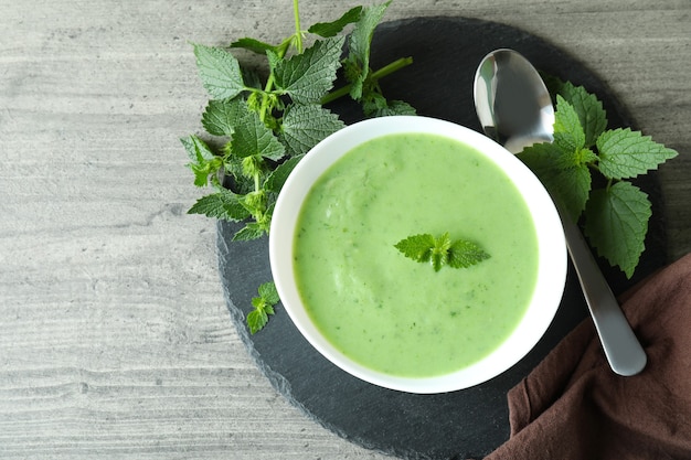 Concepto de comida sana con sopa de ortiga en mesa con textura gris