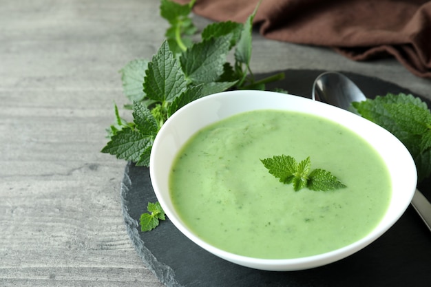 Concepto de comida sana con sopa de ortiga en mesa con textura gris