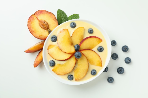 Concepto de comida sana con yogur de melocotón sobre fondo blanco.