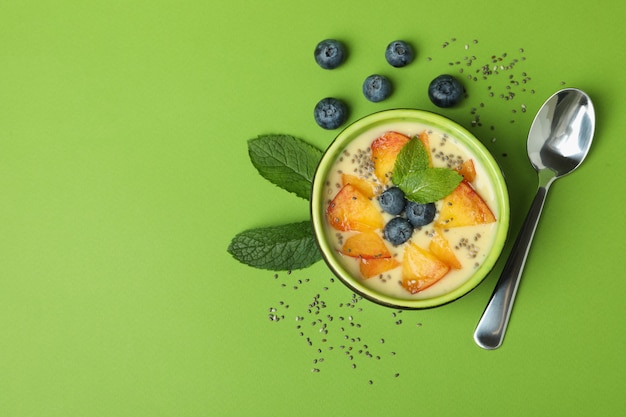 Concepto de comida sana con yogur de melocotón sobre fondo verde