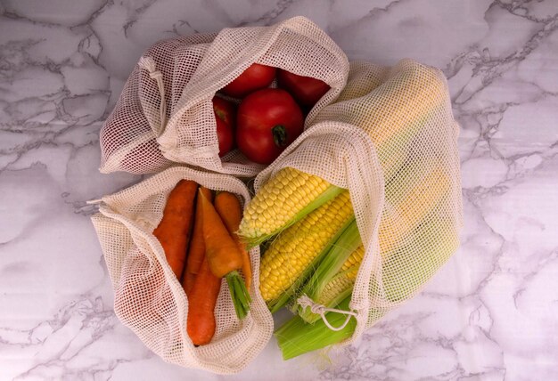 Foto concepto de compra sin desperdicio verduras en bolsas de ecoalgodón sobre la mesa