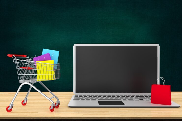 Foto concepto de compra en línea. bolsas de papel en carro de compras en la tabla de madera con el teclado de la computadora portátil.