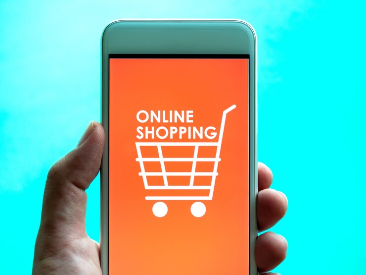 Foto concepto de compra en línea. las palabras "compras en línea" y el icono del carrito de compras sobre fondo naranja en la pantalla del teléfono inteligente.