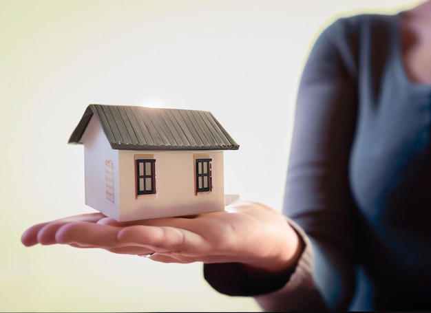 Concepto de compra o construcción de una nueva casa Mano masculina que muestra la oferta de una nueva casa de ensueño en el campo vacío con espacio para copiar