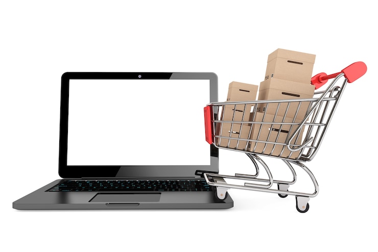 Foto concepto de compra online. carro de la compra con cajas sobre un portátil sobre un fondo blanco.