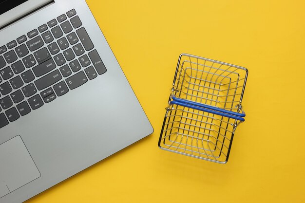 Concepto de compra online Laptop y mini cesta de la compra