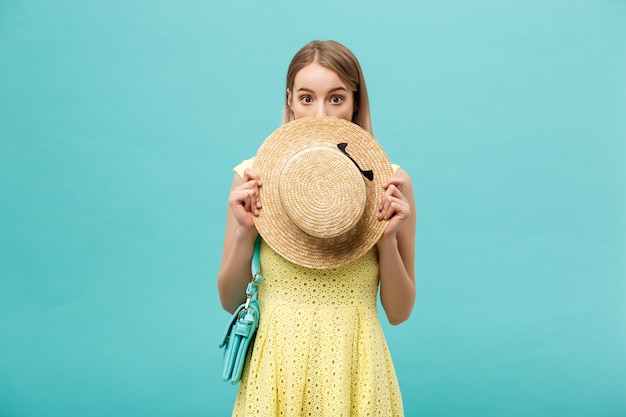 Concepto de compra y venta: hermosa joven infeliz en elegante vestido amarillo con bolsa de compras.
