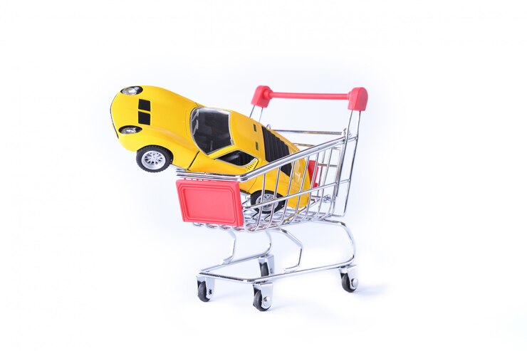 Foto concepto de comprar un auto nuevo. coche de juguete en cesta aislada
