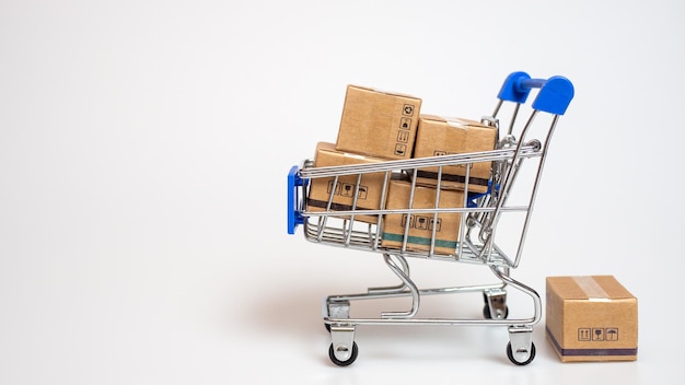 Concepto de compras Cajas de papel en carrito de compras azul sobre fondo blanco compras en línea