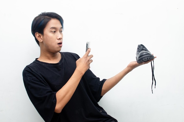concepto de compras desde casa. un concepto de compras en línea ilustrado por un hombre asiático sosteniendo un teléfono