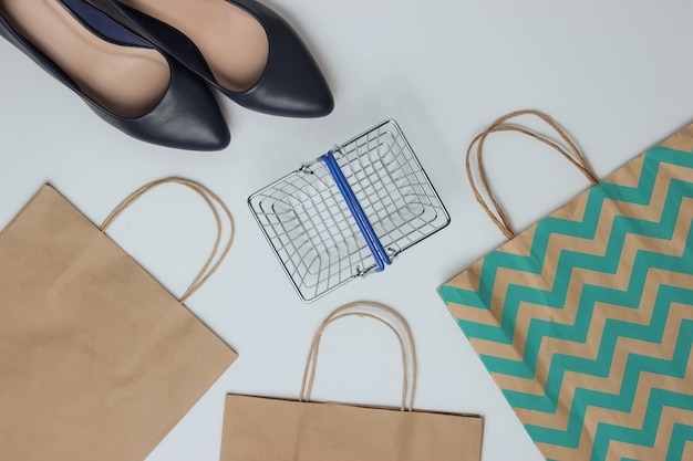 Foto concepto de compras foto de estudio de moda zapatos de tacón alto de mujer cesta de la compra y bolsas de papel