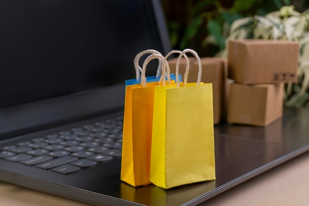 Concepto de compras en línea Cajas de entrega pequeñas Bolsas de compras para teléfonos inteligentes Soporte de cesta de compras en la computadora portátil