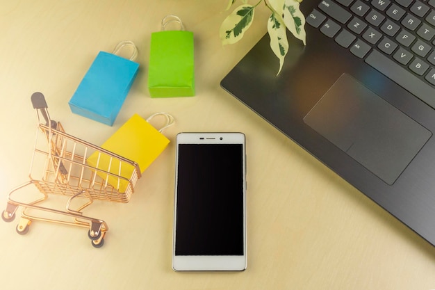 Concepto de compras en línea Cajas de entrega pequeñas Bolsas de compras para teléfonos inteligentes Soporte de cesta de compras en la computadora portátil