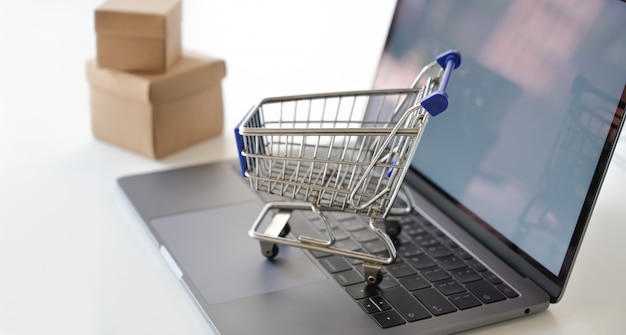 Concepto de compras en línea: carrito de compras en la computadora portátil