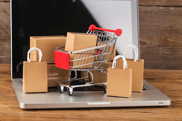 Concepto de compras en línea en casa. Cartones en un carrito de compras en un teclado portátil