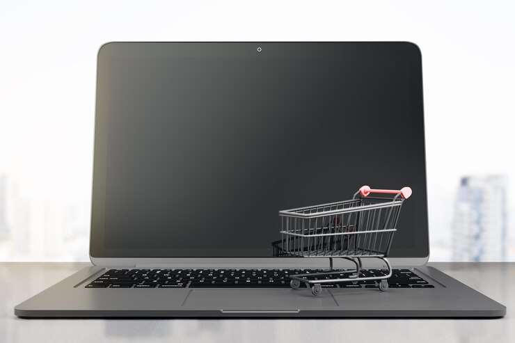 Foto concepto de compras en línea con monitor en blanco de portátil moderno y tienda de carretillas negras mockup