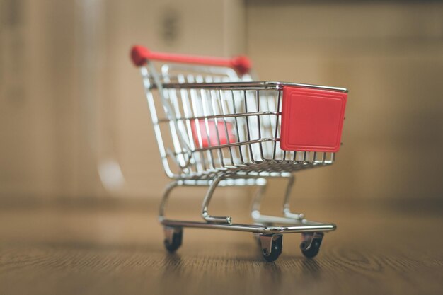 Concepto de compras en línea Pequeño carrito de compras en cajas de entrega