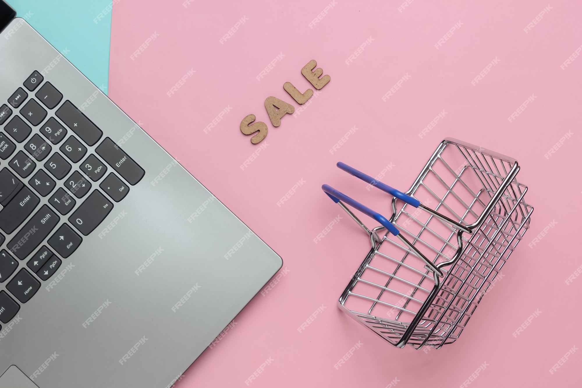 de en línea venta portátil mini cesta de la compra sobre fondo rosa azul pastel | Foto