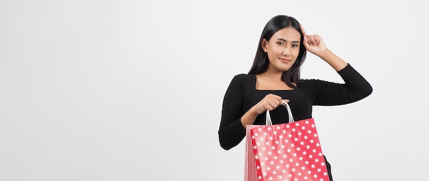 Concepto de compras de mujer. Felizmente niña y bolsas de compras durante la temporada de rebajas. Feliz joven asiática tailandesa en acción o actividad de compra de productos en tiendas o tienda online y fondo blanco.