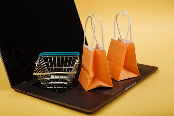 Foto concepto de compras online. bolsas naranjas y carrito de compras