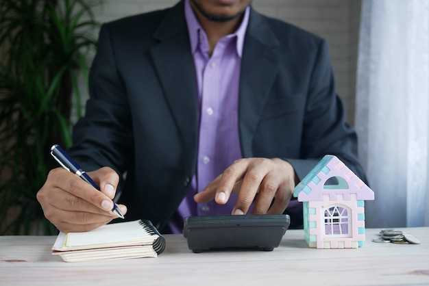 el concepto de concepto de finanzas hombre usando calculadora y escribiendo en papel