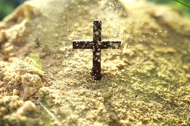 Concepto conceptual cruz negra religión símbolo silueta en hierba