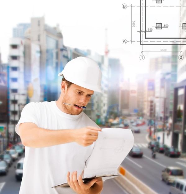 concepto de construcción, desarrollo, construcción y arquitectura - arquitecto masculino en casco mirando el plano