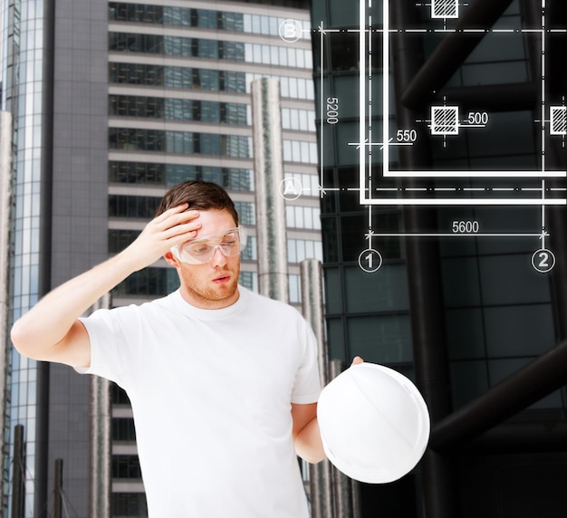 concepto de construcción, desarrollo, construcción y arquitectura - arquitecto masculino con gafas de seguridad quitándose el casco