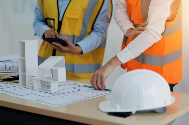 Concepto de construcción y estructura de una reunión de ingenieros o arquitectos para un proyecto que trabaja con socios y herramientas de ingeniería en la construcción de modelos y planos en el contrato de obra para ambas empresas