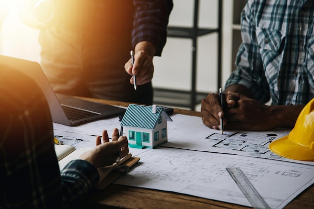 Concepto de construcción y estructura de una reunión de ingenieros o arquitectos para un proyecto que trabaja con socios y herramientas de ingeniería en la construcción de modelos y planos en el contrato de obra para ambas empresas