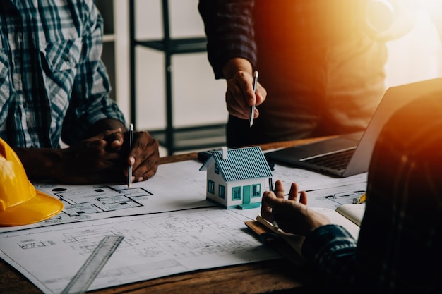 Concepto de construcción y estructura de una reunión de ingenieros o arquitectos para un proyecto que trabaja con socios y herramientas de ingeniería en la construcción de modelos y planos en el contrato de obra para ambas empresas