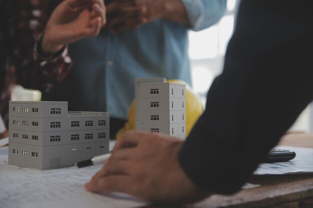 Concepto de construcción y estructura de una reunión de ingenieros o arquitectos para un proyecto que trabaja con socios y herramientas de ingeniería en la construcción de modelos y planos en el contrato de obra para ambas empresas