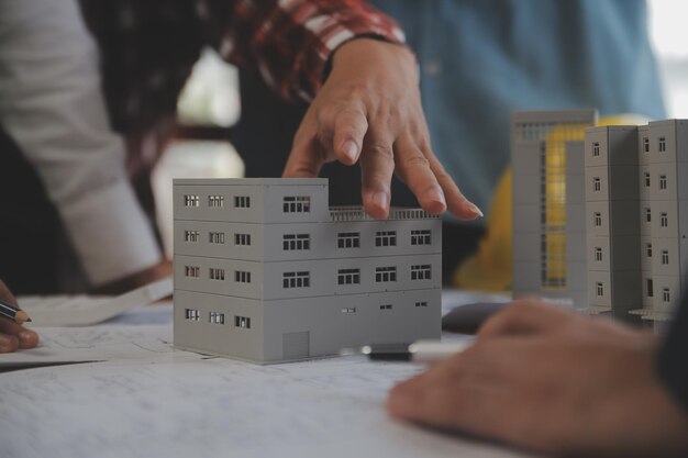 Concepto de construcción y estructura de una reunión de ingenieros o arquitectos para un proyecto que trabaja con socios y herramientas de ingeniería en la construcción de modelos y planos en el contrato de obra para ambas empresas