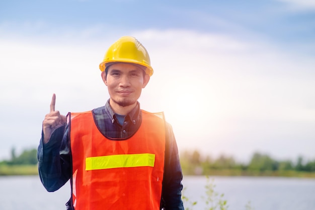 Concepto de construcción del trabajador trabajador asiático construcción sonrisa feliz de pie al aire libre en la construcción del sitio