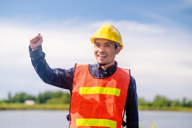 Concepto de construcción del trabajador trabajador asiático construcción sonrisa feliz de pie al aire libre en la construcción del sitio