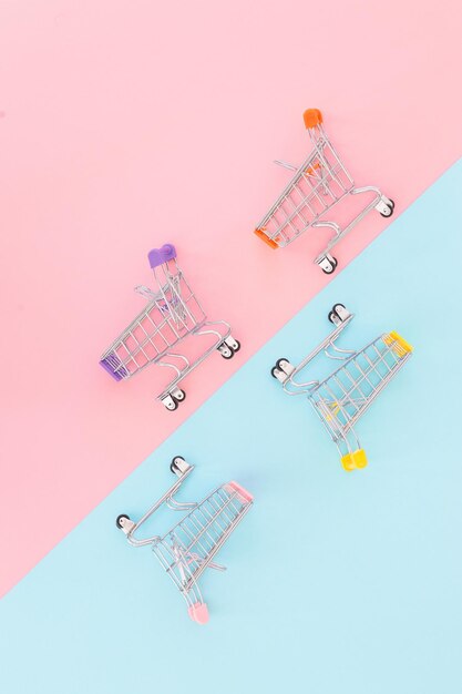 Concepto de consumidor mini carrito de compras para comprar en una vista superior de minimalismo de fondo de color