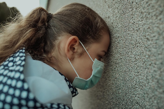Concepto de coronavirus y contaminación del aire pm2.5. Niña pequeña con máscara para proteger pm2.5. Niño niña encarcelada en casa para proteger el virus de la corona. Coronavirus de Wuhan y síntomas del virus epidémico.
