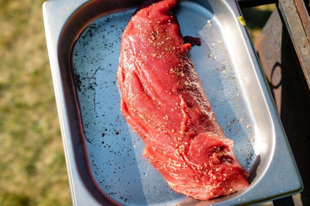 Concepto de la correcta cocción de la carne El chef prepara patatas fritas un bistec de ternera al aire libre Bistec fresco crudo servido con pimienta y sal