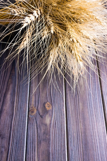 Foto concepto de cosecha de tallos de trigo en un fondo de madera