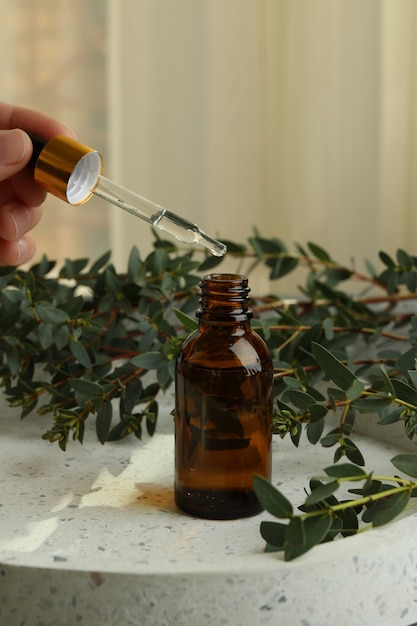 Concepto de cosmética natural con mano femenina goteando aceite de eucalipto