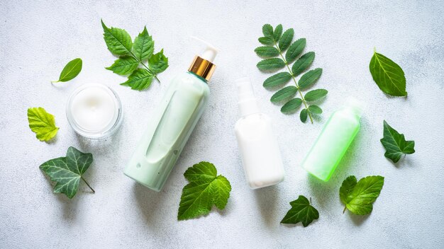 Concepto cosmético natural Producto para el cuidado de la piel crema jabón máscara tónica con plantas verdes Imagen plana