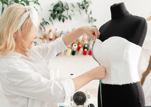 Foto concepto de costurera diseñadora de moda y medidas de costurera de pequeñas empresas en un maniquí