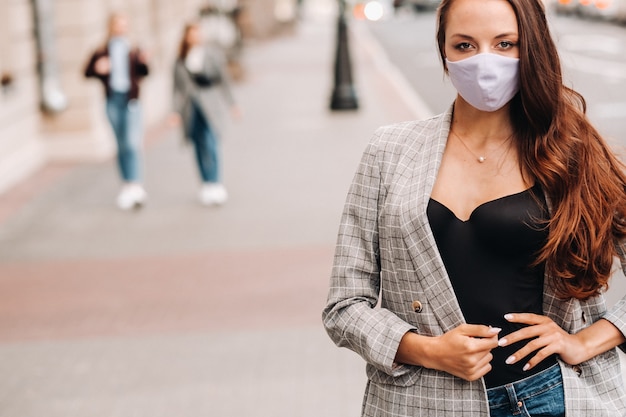 Concepto Covid-19 y contaminación atmosférica pm2.5. Pandemia, retrato de una mujer joven con máscara protectora en la calle. Concepto de salud y seguridad.