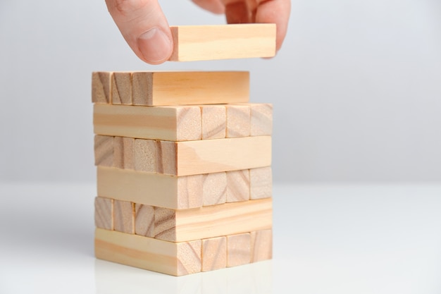 Concepto de creación de gran fecha. La mano sostiene los bloques de madera en un espacio en blanco.