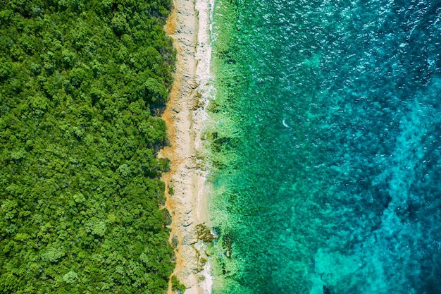 Concepto creativo de playa mínima. Diseño de vacaciones de verano con agua azul y arena sobre fondo brillante. Endecha plana.