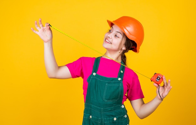 Concepto de crecimiento niña con instrumentos de cinta métrica para la renovación del apartamento felicidad y desarrollo infantil midiendo la altura arquitecto jugando con herramientas Bienvenido a mi mundo