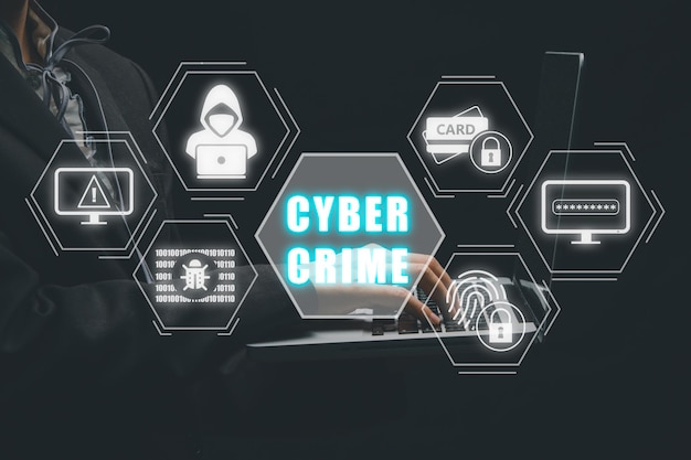 Concepto de crimen cibernético Persona que escribe a mano en el teclado de la computadora con el icono de crimen cybernético en la pantalla virtual Concepto de tecnología de seguridad de información personal de grandes datos