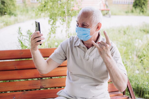 Concepto de cuarentena de coronavirus, coronavirus, hombre con mascarilla médica usando el teléfono para hacer selfie. La contaminación del aire