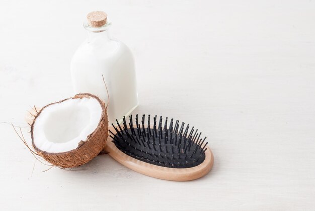 concepto de cuidado del cabello con aceite de coco sobre fondo blanco